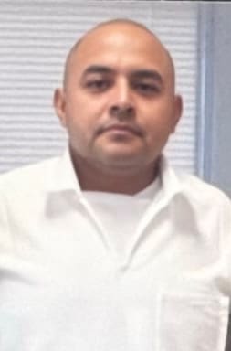 Headshot of a bald man in a white shirt.